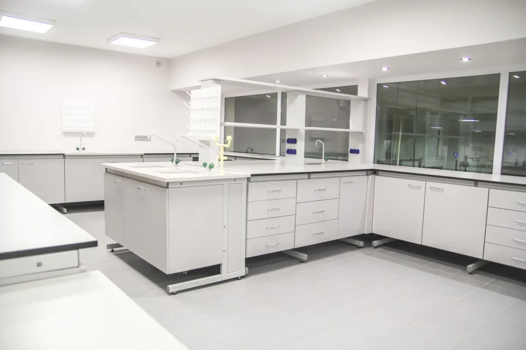 Kompleksowa zabudowa laboratorium z wyspą, zlewami i panelami mediów.